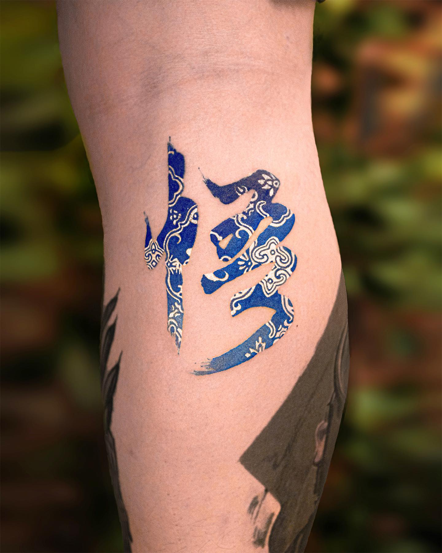 White and Blue Chinese Symbol Tattoo on Leg